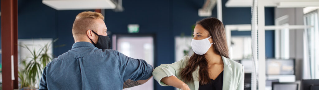 Two business colleagues greeting with elbow in office. Business people bump elbows in office for greeting during covid-19 pandemic.