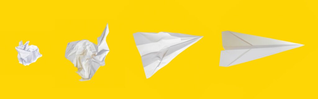 Stages of a paper airplane against yellow
